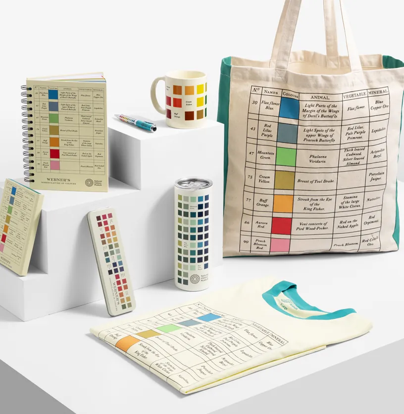 Museum merchandise range printed with a historic colour chart: tote bag, T-shirt, notebooks, mug, bottle and pencil case